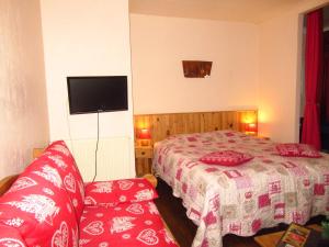 a bedroom with a bed and a couch and a tv at Gîtes la Mexicaine in Jausiers