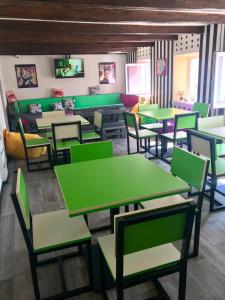 a restaurant with green tables and chairs at Lucky Hostel на Крещатике in Kyiv