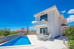 a villa with a swimming pool and a house at Villa ELA - Town Krk in Krk