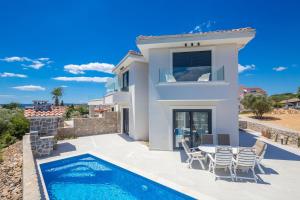 a villa with a swimming pool and a house at Villa ELA - Town Krk in Krk