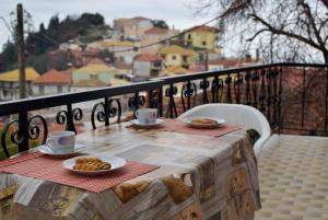 a table with cups and plates of food on a balcony at Amazing View Maisonette in Parga