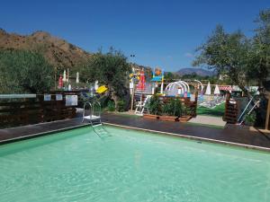 a swimming pool with a slide and a playground at Glamping Alcantara in Motta Camastra