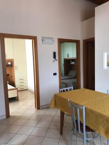 a dining room with a table and chairs and a bedroom at Appartamenti Isola Verde in Villa