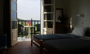 - une chambre avec un lit et une vue sur un balcon dans l'établissement Dionisis Studios, à Város