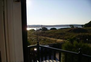 a room with a balcony with a view of the water at Dionisis Studios in Város +9 photos