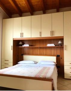 a bedroom with a large bed with white cabinets at Appartamenti Isola Verde in Villa