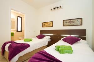 2 łóżka w pokoju z fioletowymi i zielonymi ręcznikami w obiekcie Ereza Villas Las Buganvillas w mieście Playa Blanca +17 zdjęć