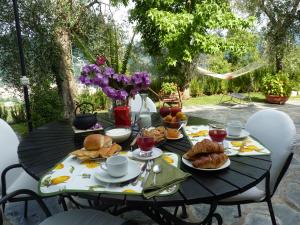 la gatta sul sentiero في San Salvatore: طاولة سوداء مع طعام الإفطار عليها