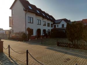 une maison blanche avec une clôture devant elle dans l'établissement Pension Schulze, à Oranienbaum-Wörlitz