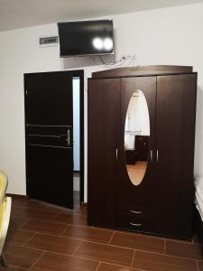 a bathroom with a mirror and a tv on a wall at Pokoje o wysokim standardzie in Słupsk