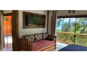 a living room with a couch and a balcony at Siriúba Reserve in Ilhabela