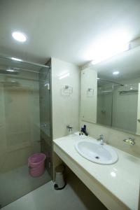 a bathroom with a sink and a shower and a toilet at Hotel Guruvayur Darshan in Guruvāyūr