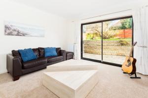 uma sala de estar com um sofá e uma guitarra em Drayton Manor House FREE parking em Tamworth