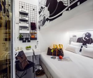 a white room with a bench and a chair at Wom Allenby Pod Hotel - a member of Brown Hotels in Tel Aviv