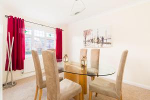 a dining room with a glass table and chairs at Drayton Manor House FREE parking in Tamworth