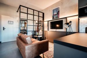 uma sala de estar com um sofá castanho e uma mesa em CLOUD No7 LOFTS em Stuttgart