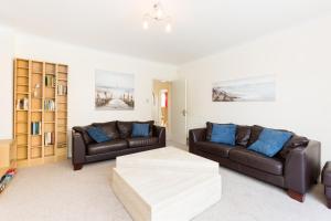a living room with two leather couches and a coffee table at Drayton Manor House FREE parking in Tamworth