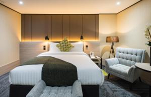 une chambre d'hôtel avec un lit et une chaise dans l'établissement Aerotel London Heathrow, Terminal 2 & Terminal 3, à Hillingdon