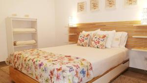 a bedroom with a large bed with a wooden headboard at Islet House in São Roque