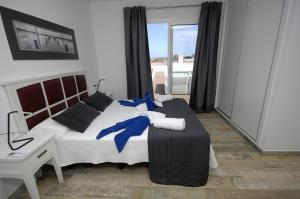 een slaapkamer met een bed, een bureau en een raam bij Villa Maria by Villalia in Playa Blanca