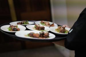 uma pessoa segurando uma bandeja de comida em uma mesa em Stay Margaret River em Margaret River