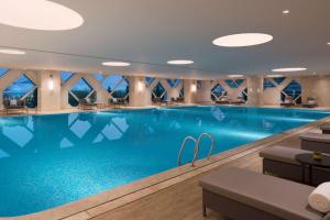 a large swimming pool with blue water in a hotel lobby at Hyatt Regency Shenzhen Airport in Bao'an