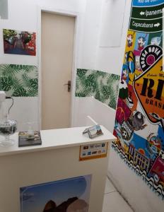 una habitación con un mostrador y una pared con carteles en Sobrado Botafogo en Río de Janeiro