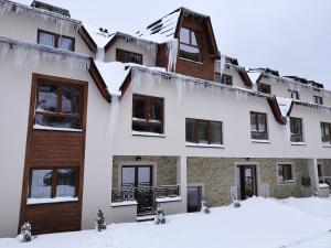an apartment building with snow on the ground at Sky Cabin Apartments in Kopaonik