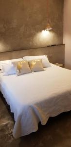 a large white bed with white sheets and pillows at Affittacamere Joss in La Spezia