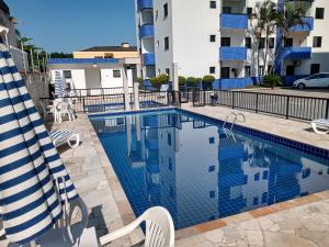 a swimming pool with chairs next to a building at Ed.fragatas residence in Bertioga