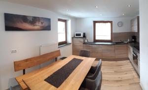 una sala da pranzo con tavolo in legno e una cucina di Haus Hell a Mayrhofen