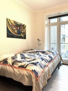 una camera da letto con un letto e un dipinto sul muro di ApartmentInCopenhagen Apartment 1436 a Copenaghen
