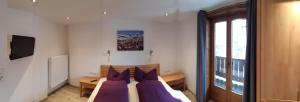 una camera da letto con letto e cuscini viola di Haus Hell a Mayrhofen