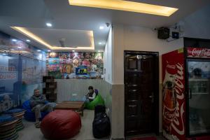 two men sitting in a room with a soda machine at Yes Boss By Backpackers Heaven Near New Delhi Train Station in New Delhi