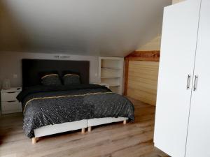 een slaapkamer met een bed met een zwart dekbed bij L'esca'Lac in Grande Riviere
