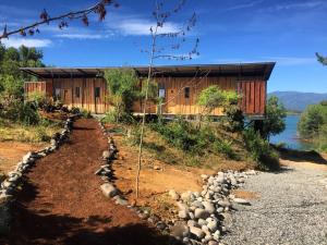 uma casa no lado de uma colina com uma estrada em Lodge Colbún em Colbún Alto