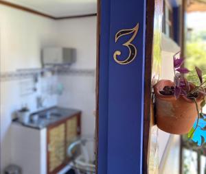a blue door with a potted plant in a kitchen at Vila Pequeá Ilhabela in Ilhabela