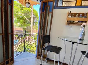 a room with a balcony with a table and chairs at Vila Pequeá Ilhabela in Ilhabela