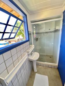 a bathroom with a glass shower and a sink at Vila Pequeá Ilhabela in Ilhabela