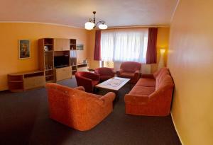 ein Wohnzimmer mit einem Sofa, Stühlen und einem Tisch in der Unterkunft Hotel Ranč u Edyho in Námestovo