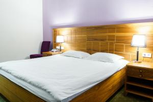 a bedroom with a large bed with a wooden headboard at The Square in Astana