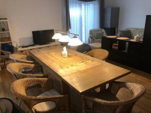Ferienhaus Mainz في ماينز: غرفة معيشة مع طاولة وكراسي خشبية
