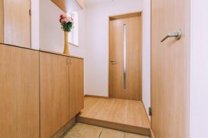 a hallway with a door and a vase of flowers at Stay In Biei in Biei