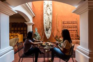 two women sitting at a table with food at Hotel Ayook in Oaxaca City