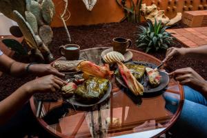 a group of people sitting around a table with food at Hotel Ayook in Oaxaca City