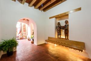 a hallway with a bench and a statue of two men at Hotel Ayook in Oaxaca City