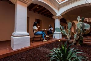 two women sitting at a table in a room with cactus at Hotel Ayook in Oaxaca City +37 photos