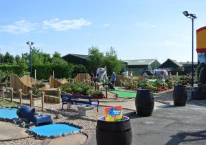 a garden with a playground with a play area at ML66 8 BERTH CARAVAN GOLDEN PALM CHAPEL ST LEONARDS in Chapel Saint Leonards