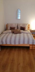 a large bed in a bedroom with wooden floors at apartmán U Moravy in Olomouc