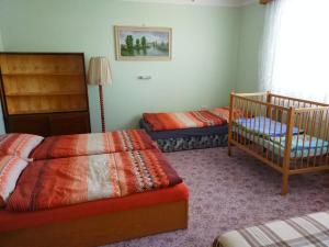 1 Schlafzimmer mit 2 Einzelbetten und einem Kinderbett in der Unterkunft Ubytování U Jezérka in Ratíškovice